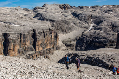 People walking on rocks against mountains