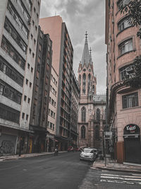 Street amidst buildings against sky in city