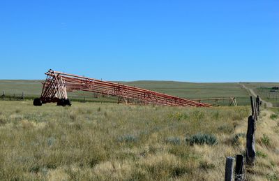 Agricultural machinery on farm against clear blue sky