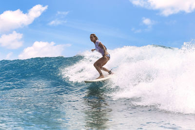 Woman surfing on surfboard in sea