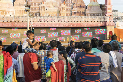 Rear view of people standing outside temple