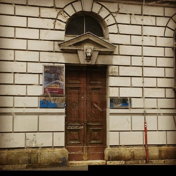 architecture, built structure, building exterior, window, wall - building feature, door, entrance, brick wall, closed, building, church, day, arch, wall, text, no people, old, low angle view, religion, graffiti