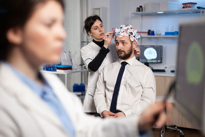 Doctors doing eeg treatment of man