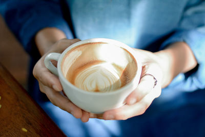 Midsection of woman holding coffee cup