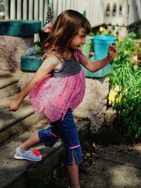 Full length of girl moving down steps in yard