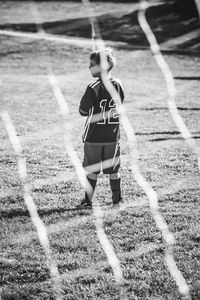 Rear view of boy standing on field