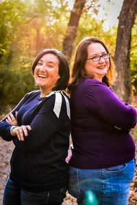 Portrait of friends standing against trees