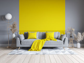 Yellow umbrella on sofa against wall at home