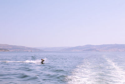 Man swimming in sea against clear sky