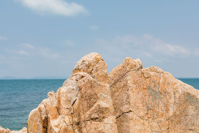 Rock formation in sea against sky