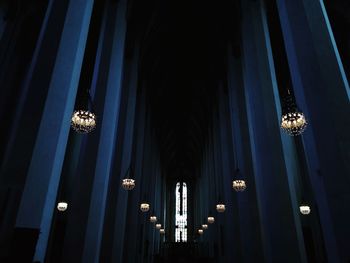 Low angle view of illuminated lights hanging from ceiling in building