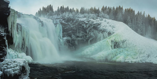 Scenic view of waterfall in forest during winter