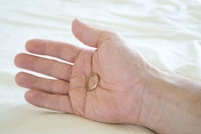 Close-up of person hand on bed