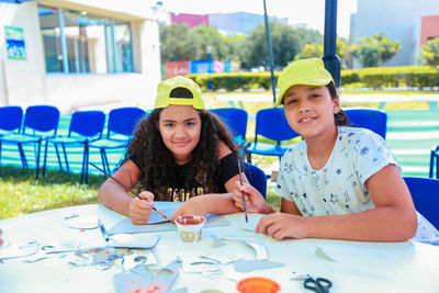 Portrait of girls painting on papers