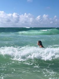 Woman swimming in sea against sky