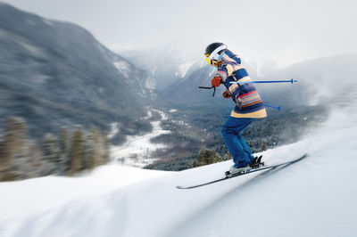 A female athlete skier rides a freeride in a winter forest in the mountains. jump against the