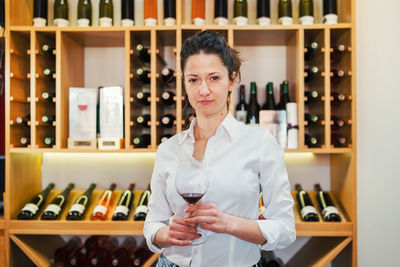 Portrait of woman holding wineglass at home