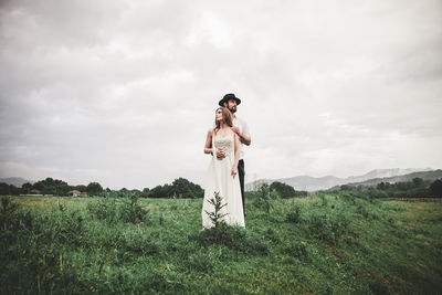 Woman standing on field against sky