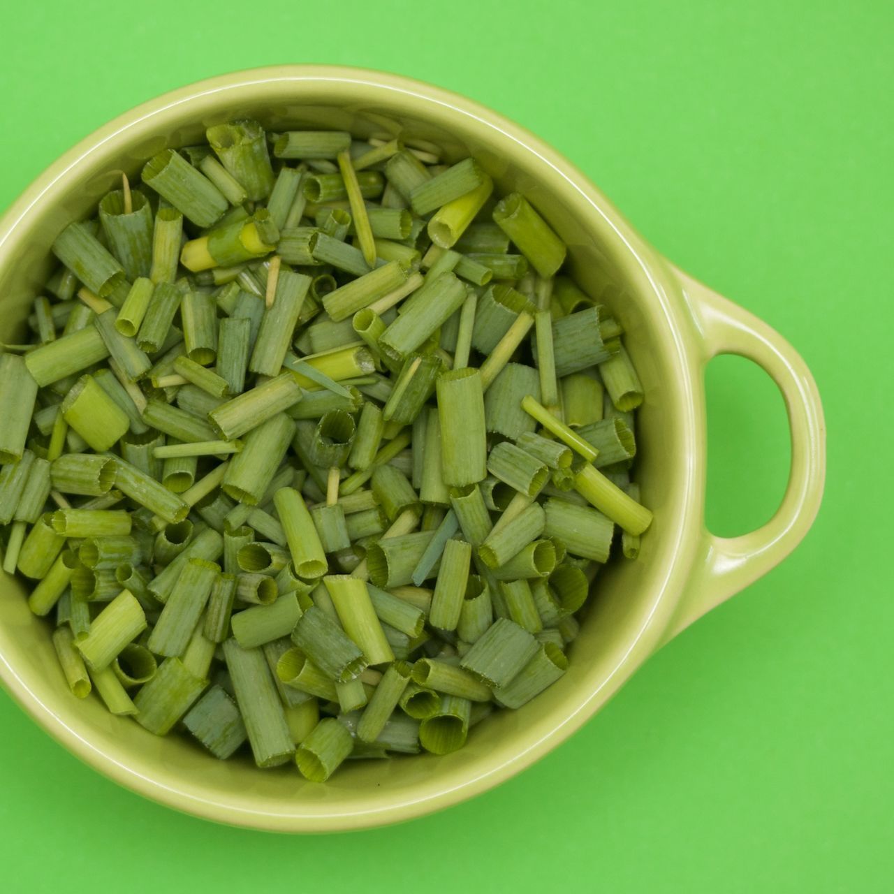 DIRECTLY ABOVE SHOT OF CHOPPED VEGETABLES IN BOWL AGAINST GREEN BACKGROUND