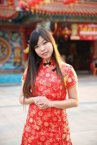 Portrait of smiling young woman standing outdoors