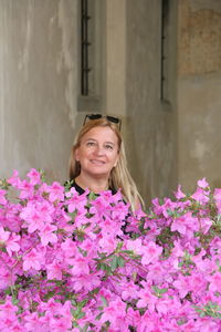 Young woman standing by pink flowers at park