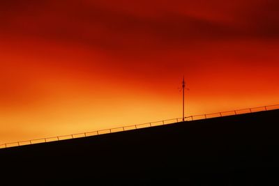 Low angle view of bridge against orange sky