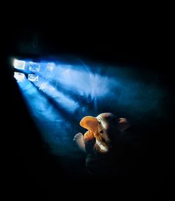 Close-up of illuminated lighting equipment against black background