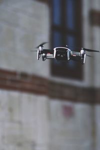 A young man controls a quadrocopter with a remote