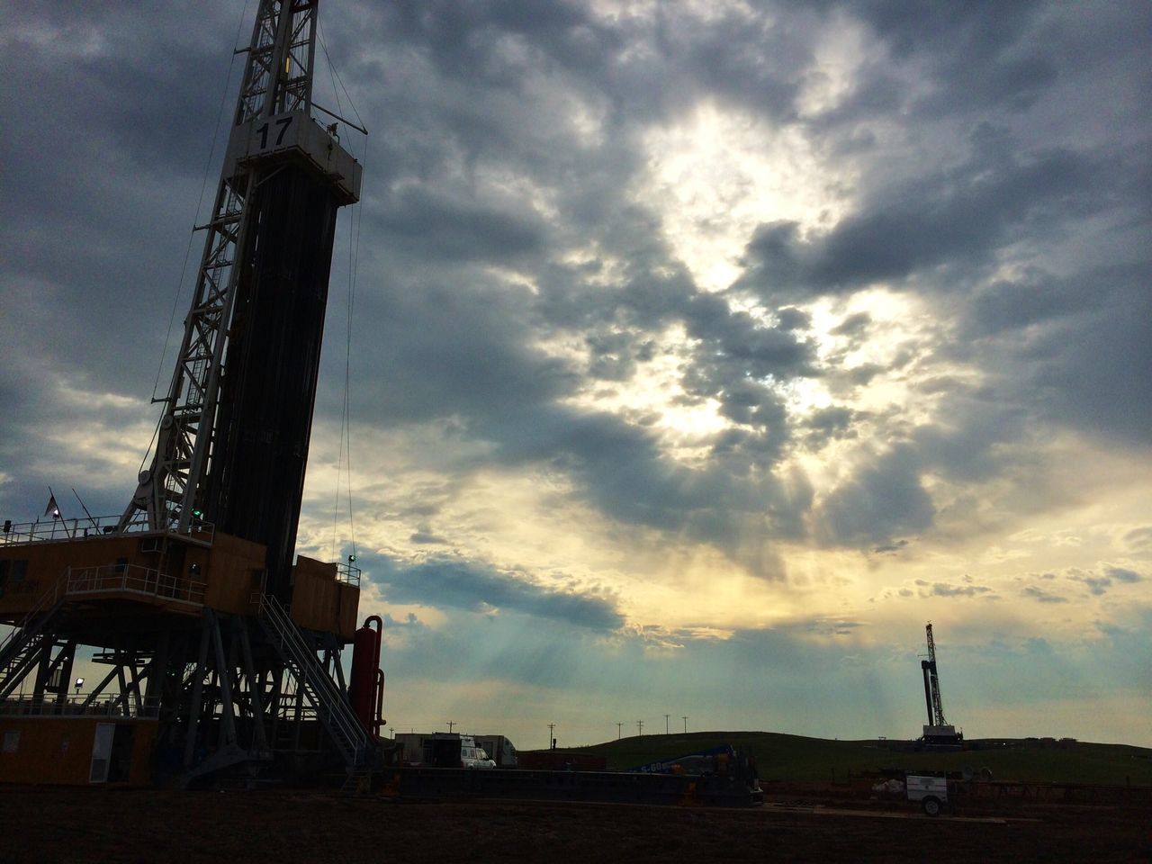 sky, built structure, architecture, crane - construction machinery, cloud - sky, industry, low angle view, construction site, building exterior, development, crane, cloudy, silhouette, construction, tall - high, cloud, sunset, tower, dusk, travel destinations