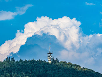 Low angle view of tv- tower against cloudy sky