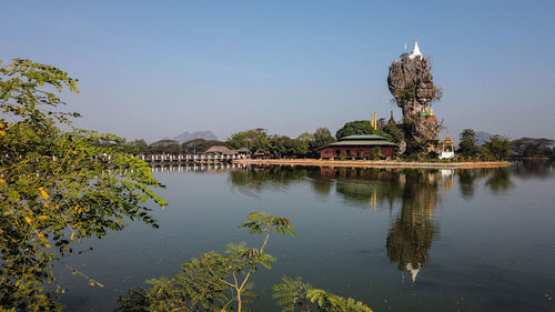 Arch bridge over river by building against sky