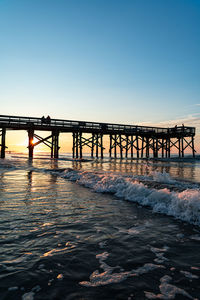 Pier over sea against clear sky