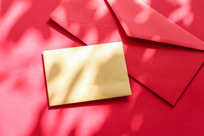 High angle view of envelope on red background