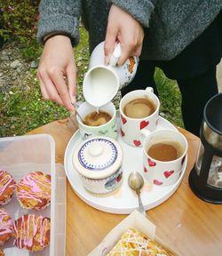 High angle view of woman pouring coffee into cup