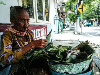Man sitting at street market in city