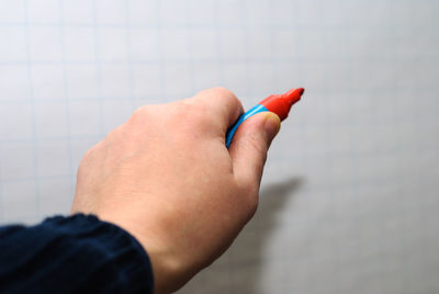 Close-up of hand holding finger against wall