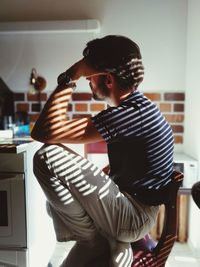 Side view of stressed man sitting at home