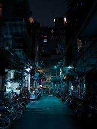 Street amidst buildings in city at night