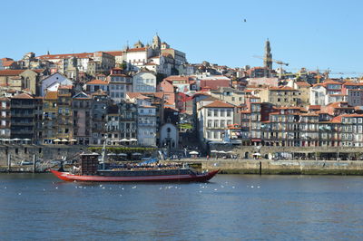 Sailboats in sea against buildings in city