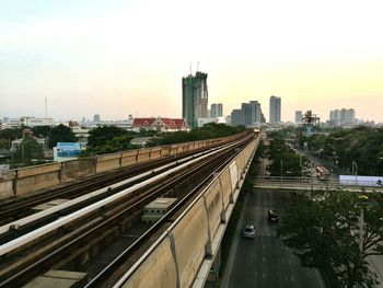 Railroad tracks in city against sky
