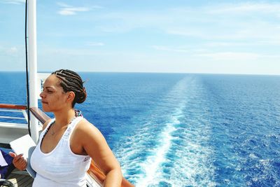 Woman standing on boat in sea against sky