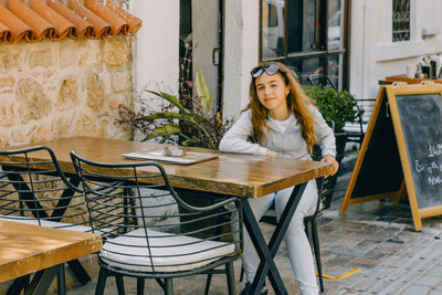 Portrait of girl sitting at table outdoor cafe