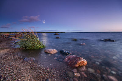 Scenic view of sea against blue sky at dusk