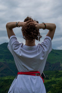 Rear view of woman standing against the sky