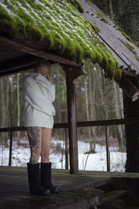 Rear view of woman standing against trees