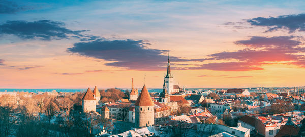 Buildings in city against sky during sunset