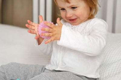 Baby girl playing tactile knobby balls. young child hand plays sensory massage ball