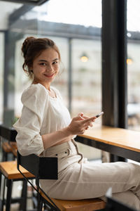 Young woman using laptop while sitting at cafe