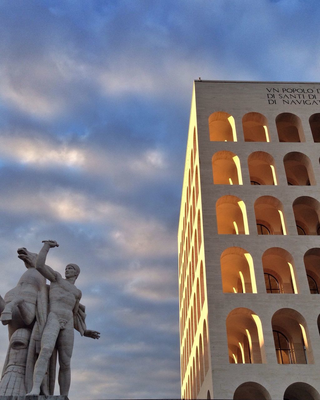 sky, low angle view, architecture, building exterior, built structure, cloud - sky, cloudy, cloud, city, building, outdoors, day, sculpture, famous place, travel destinations, history, art and craft, statue, human representation, no people