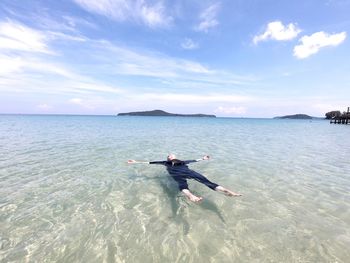 Woman floating on sea at beach